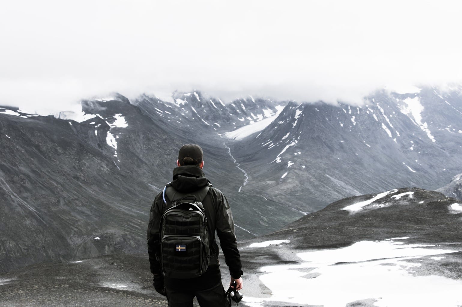 Fotógrafo en la nieve con mochila colgada a la espalda