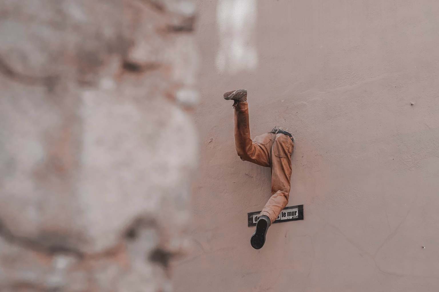 Mitad de un cuerpo asomando por un agujero de la pared