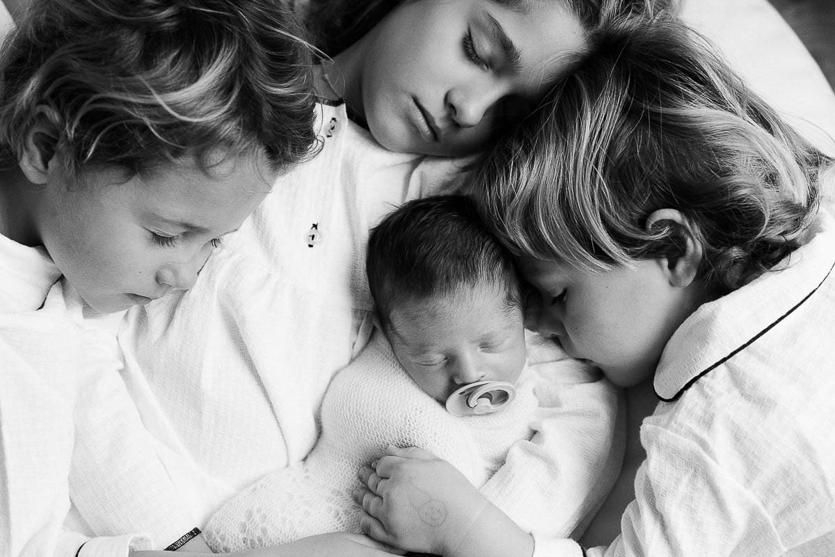 Recién nacido rodeado de sus hermanos fotografiado por Marta Schmidt