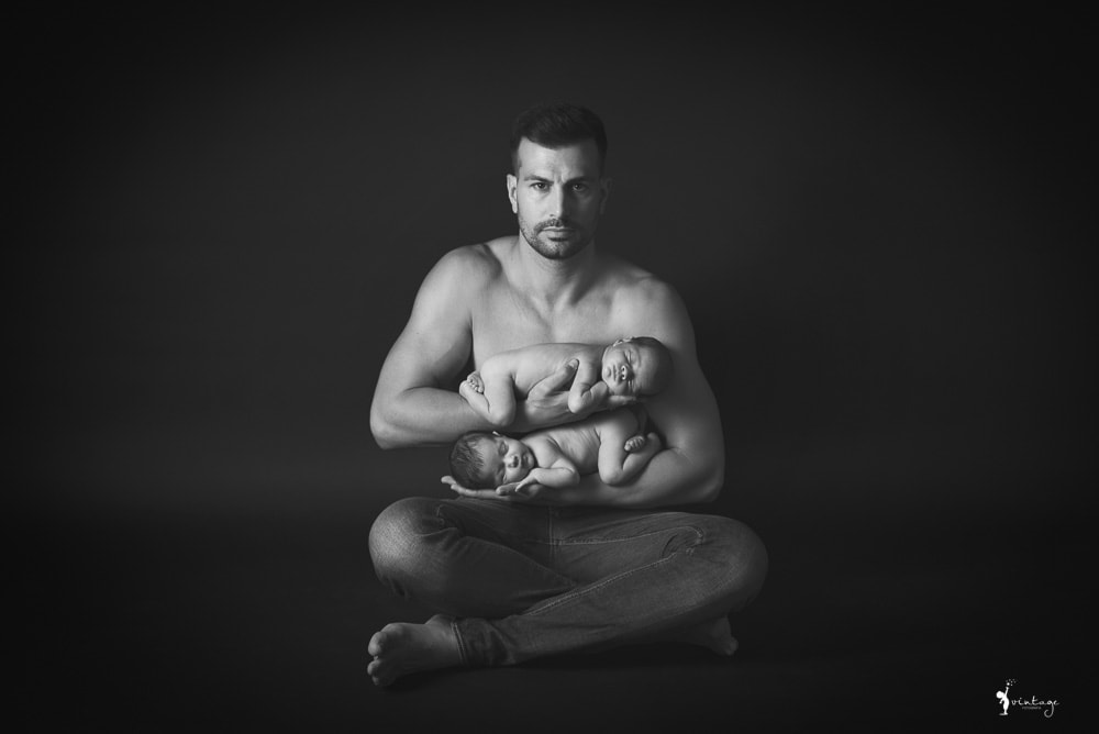 Papá con dos recién nacidos en brazos fotografiado por Vintage fotografía
