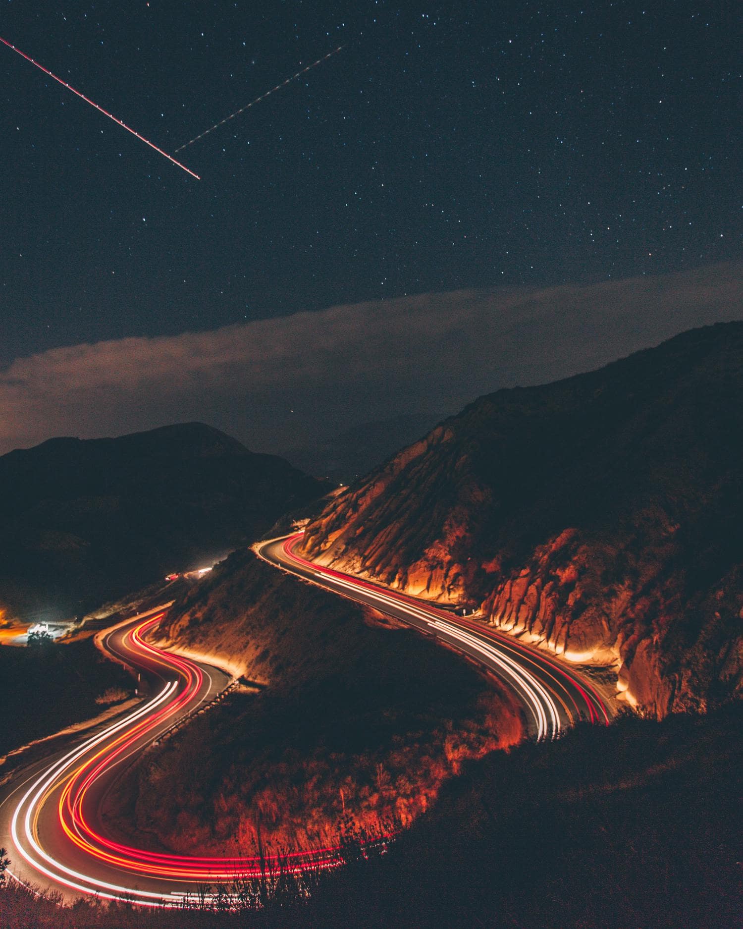 Estelas de luz de coches con estrellas de fondo en el cielo