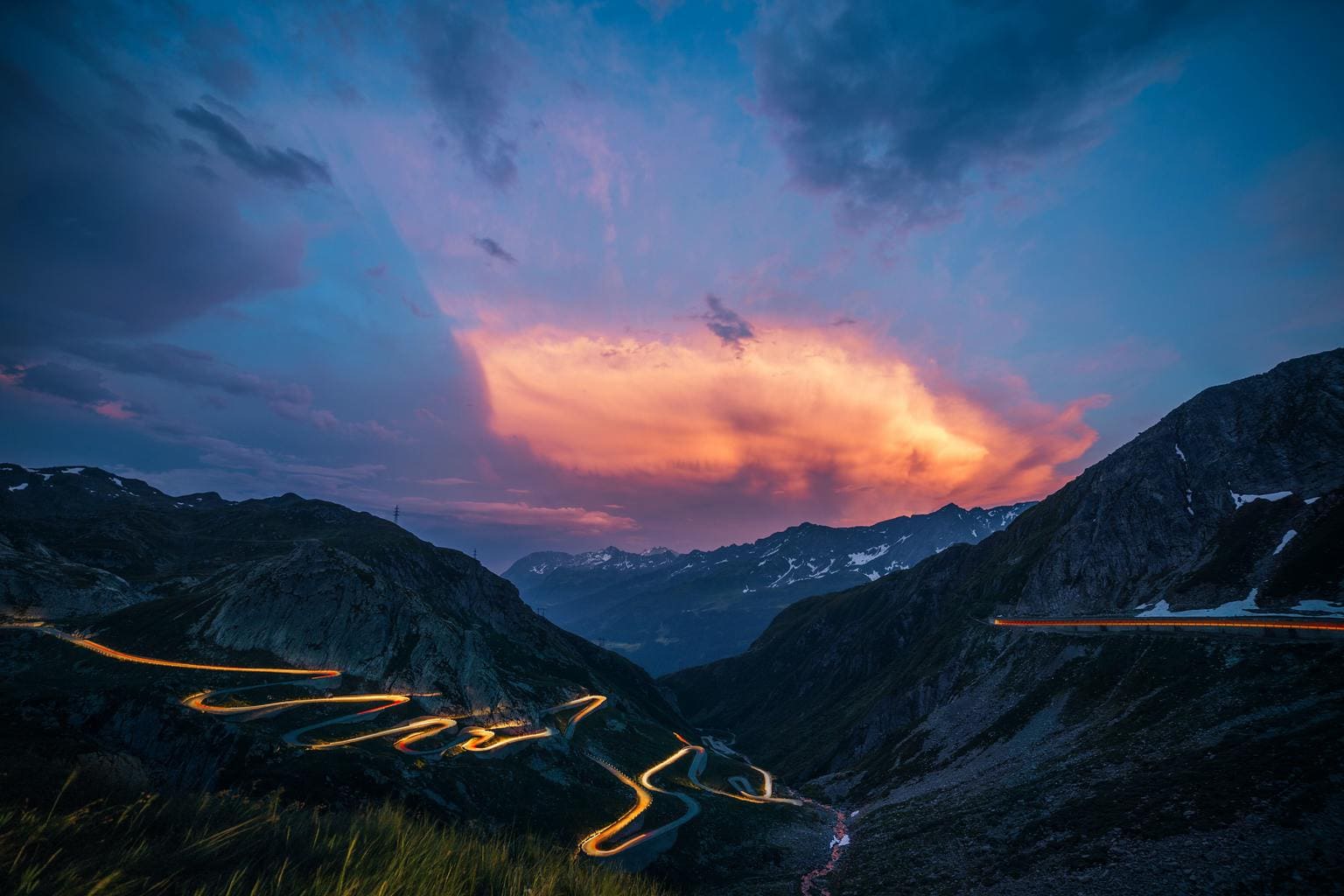 Estelas de luz en montañas con cielo de atardecer