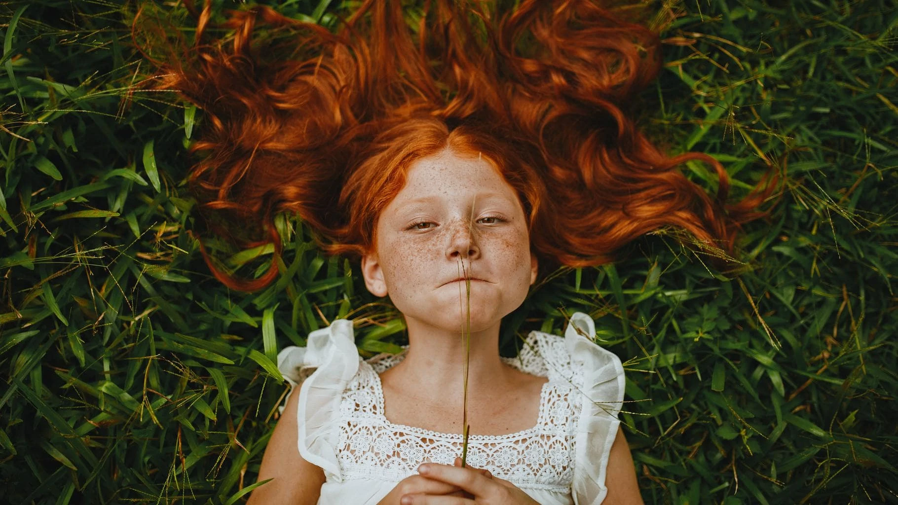 fotografía de niña tumbada en la hierba