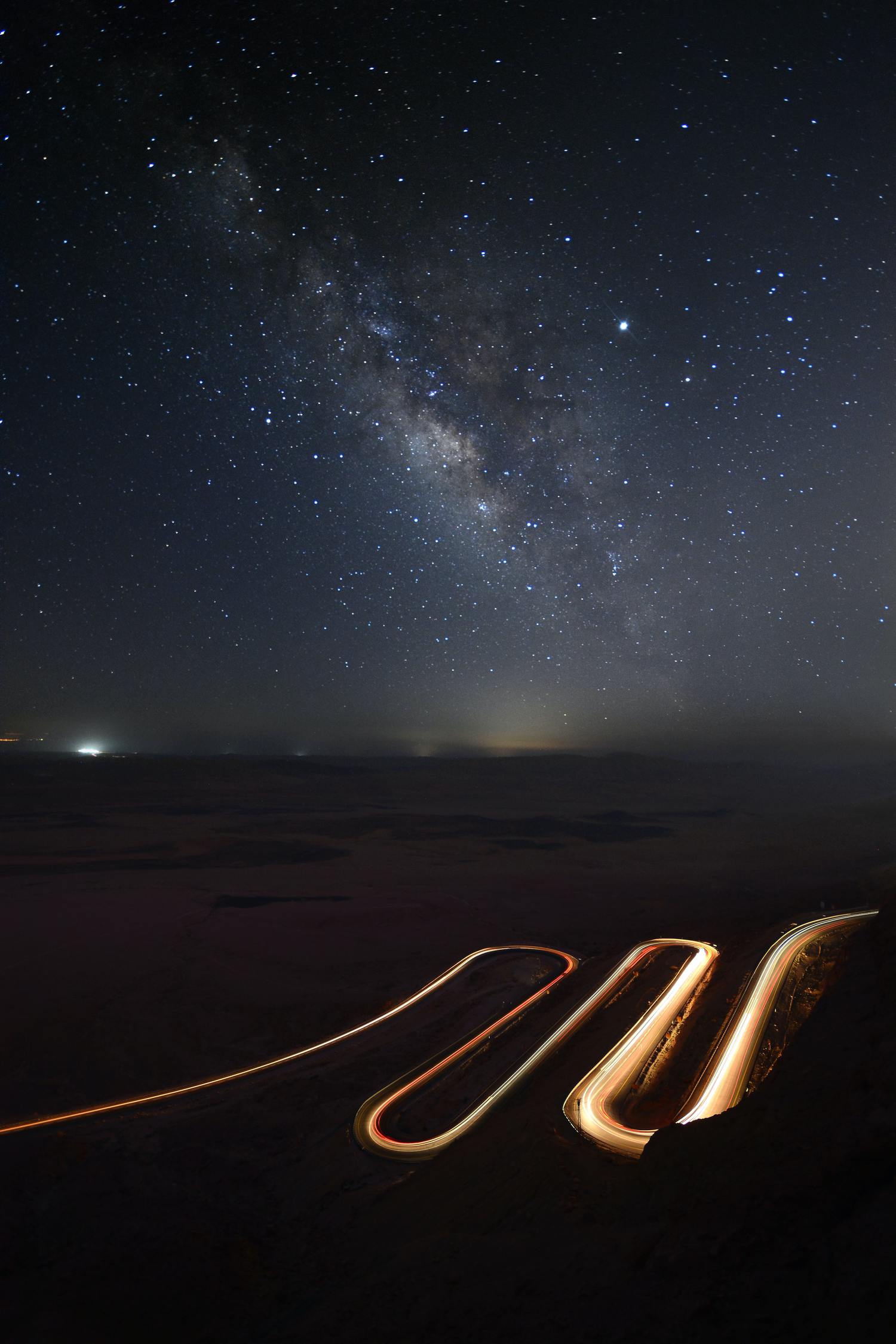 Foto de estelas del luz de coches con estrellas en el cielo