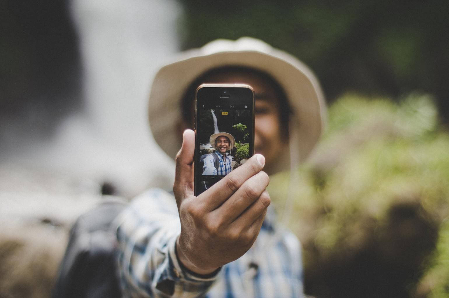 Chico haciéndose selfie con la cámara trasera del móvil.