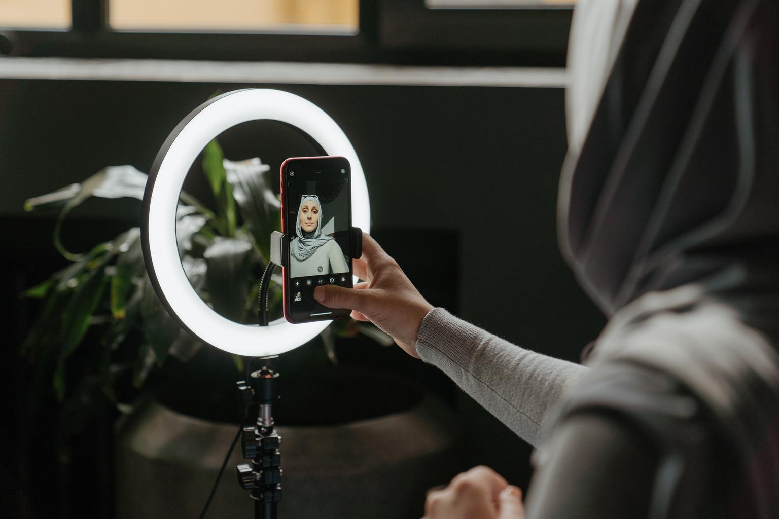 Mujer haciéndose selfie con anillo de flash tipo beauty dish para móvil