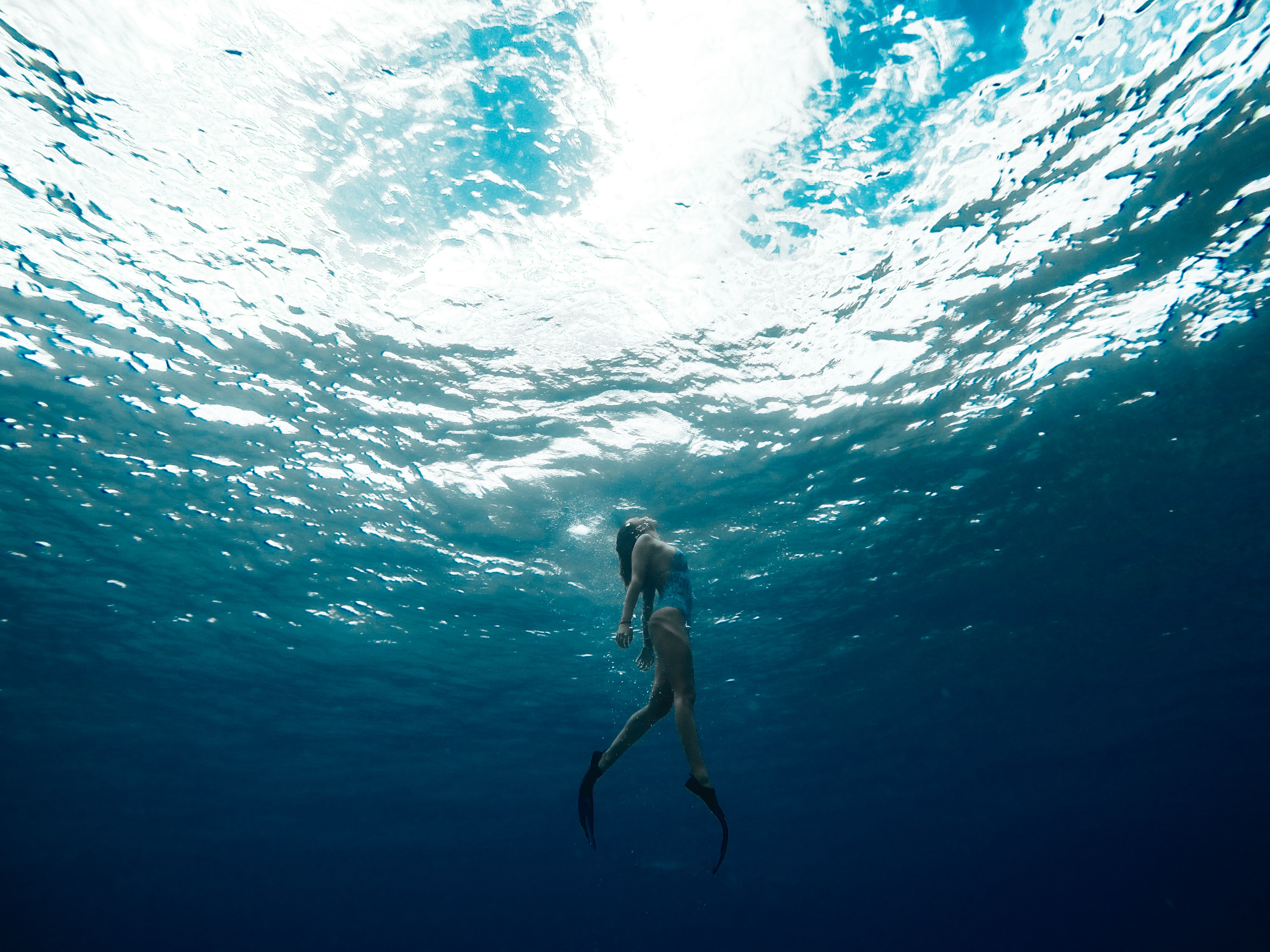 Woman with fins surfacing