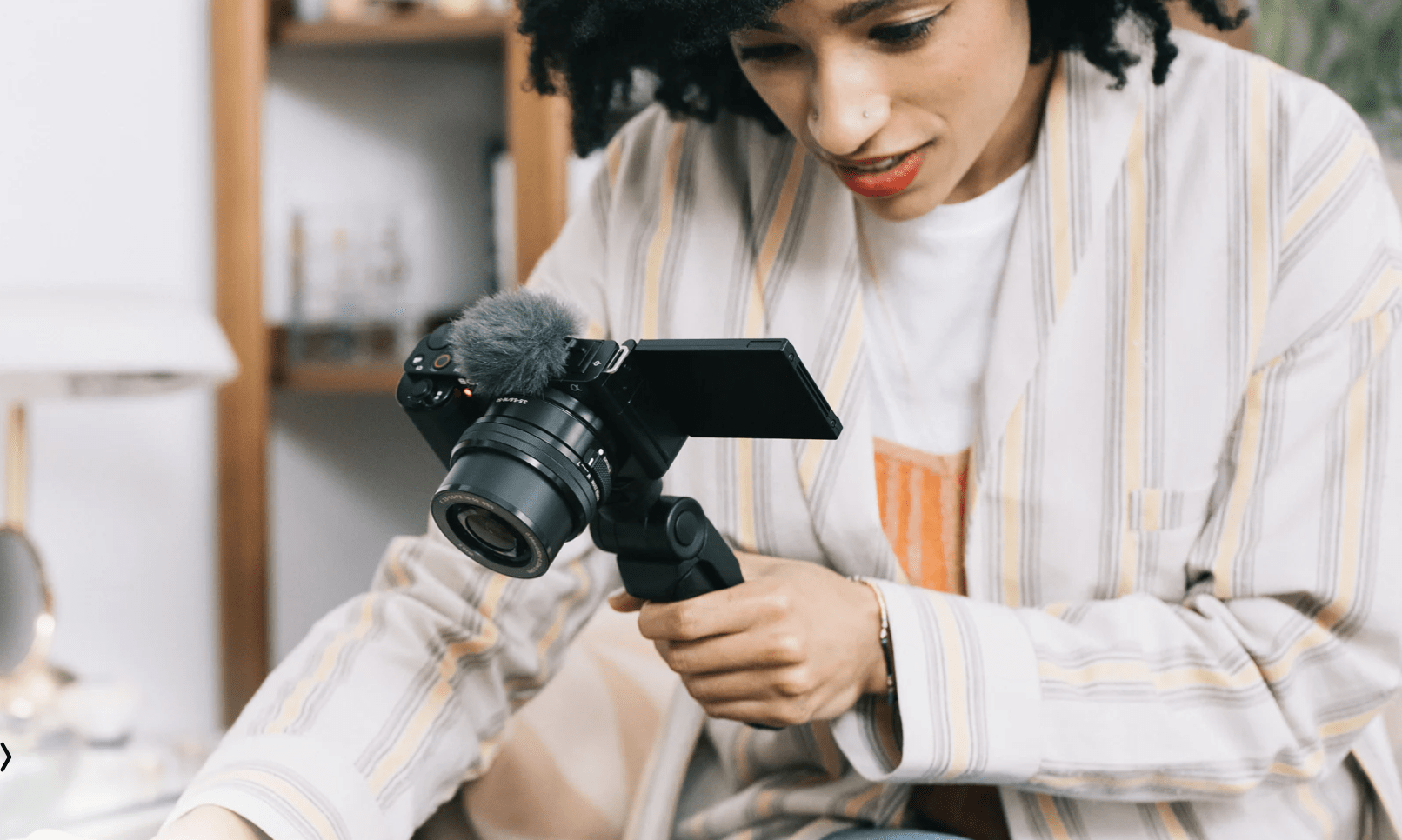 Woman with Sony ZV-E10 camera in hand