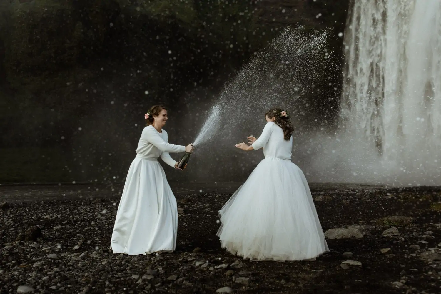 Wedding photography of two brides with cascading champagne