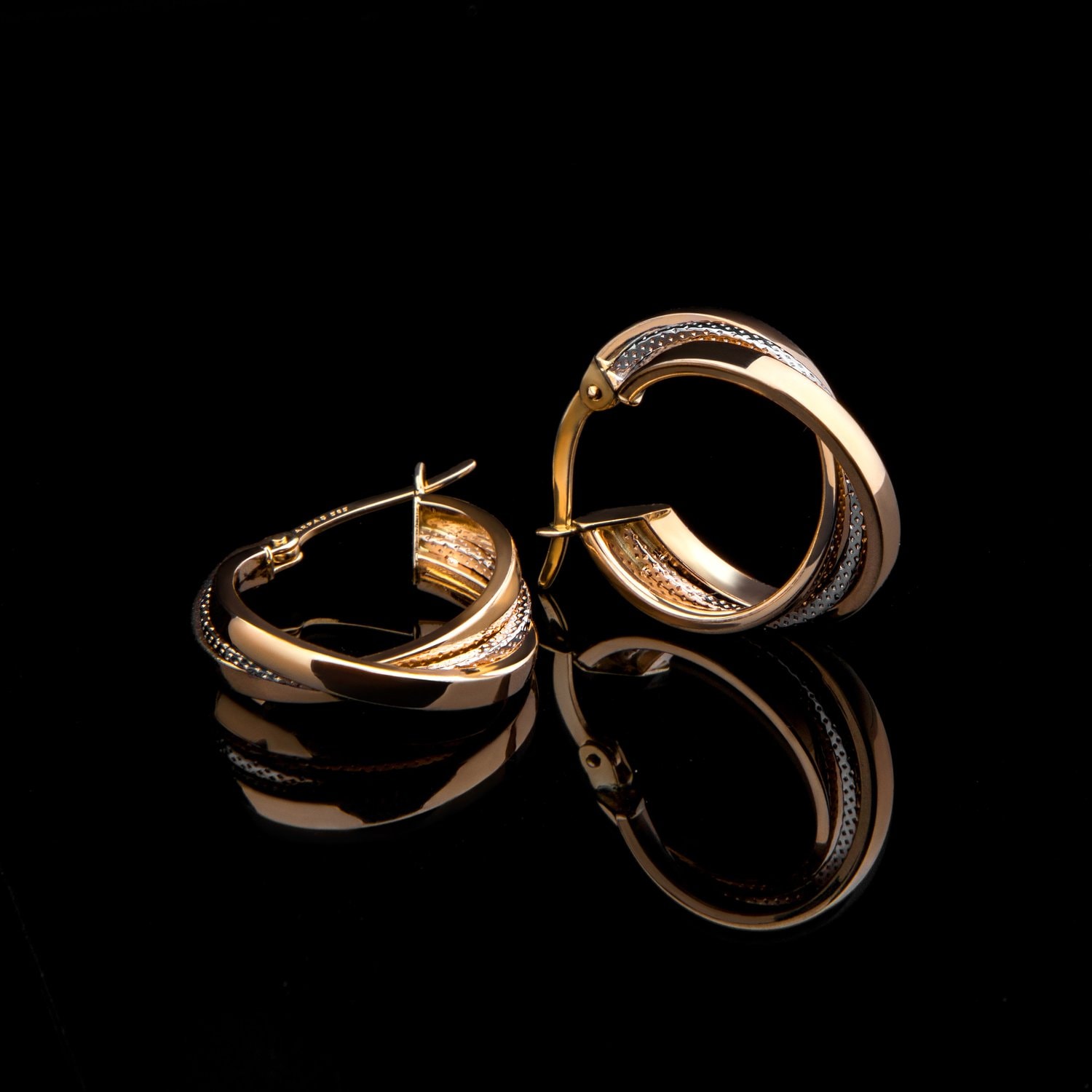 earrings photographed with a black background and composition with reflection