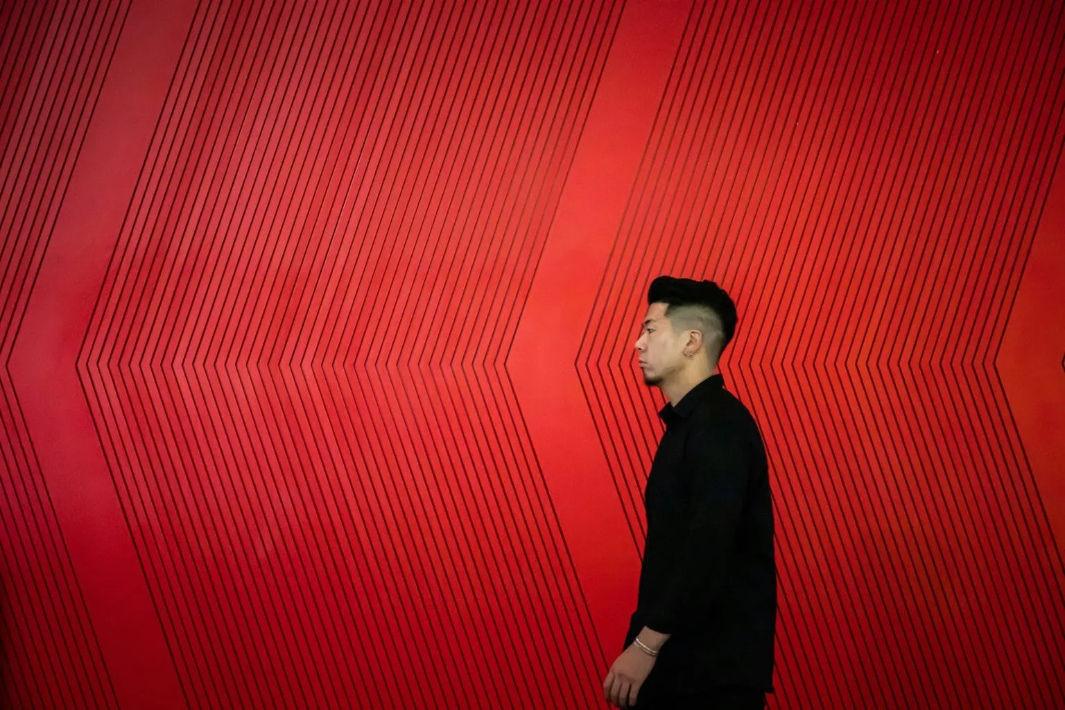 sujeto caminando con un fondo rojo