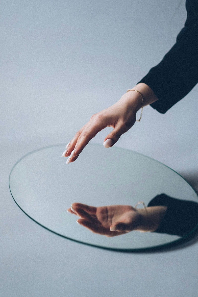 fotografía conceptual reflejo de mano en espejo