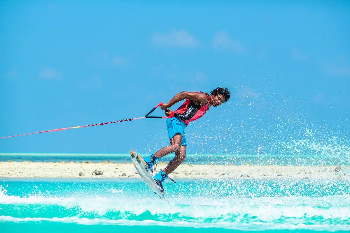 Fotografía deportiva de un joven practicando wakeboard sobre el agua