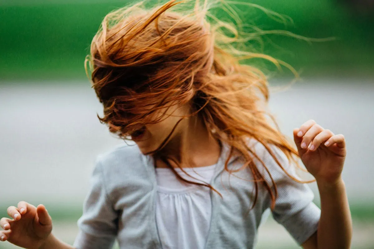 Retrato natural de niña con el cabello al viento en movimiento