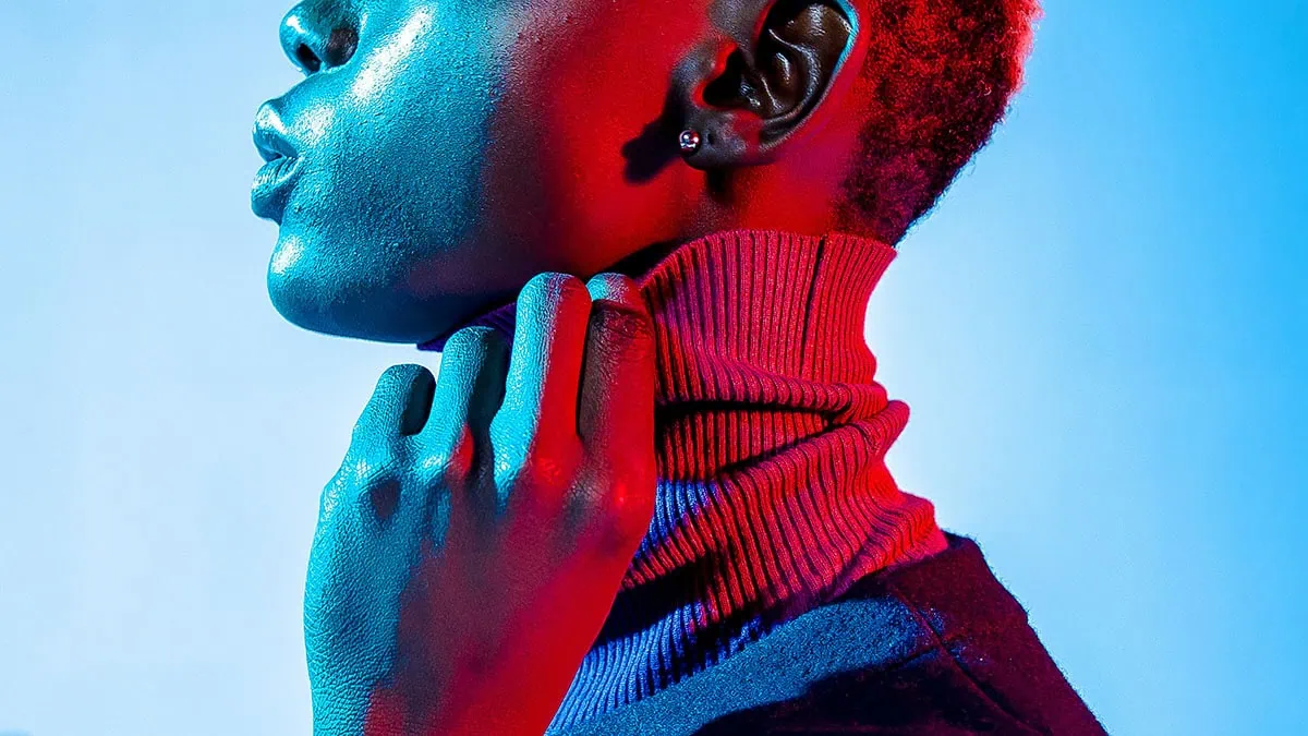 Retrato estilizado con luz roja y azul, representando las tendencias en retoque fotográfico