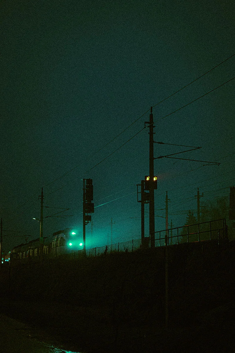 Escena urbana nocturna con neblina y tonos verdes, estilo de edición de fotos 2025