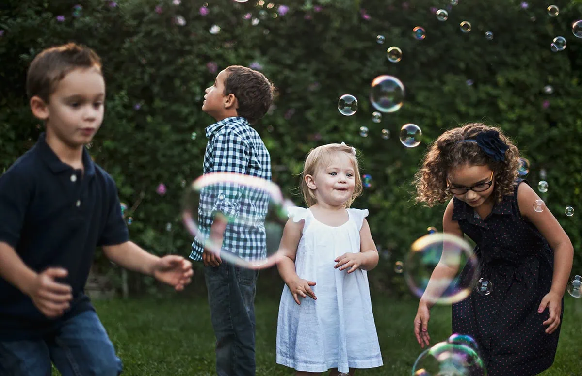 Niños jugando con burbujas al aire libre